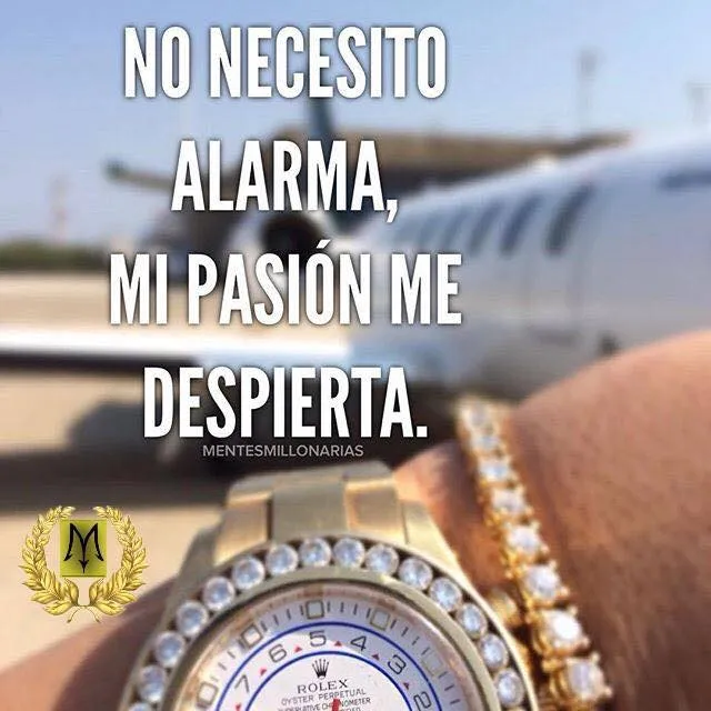 Se ve un reloj de oro en la muñeca de una persona. El reloj tiene diamantes incrustados y es de la marca Rolex. El fondo de la imagen es un avión privado y la persona que lleva el reloj está en el aeropuerto.